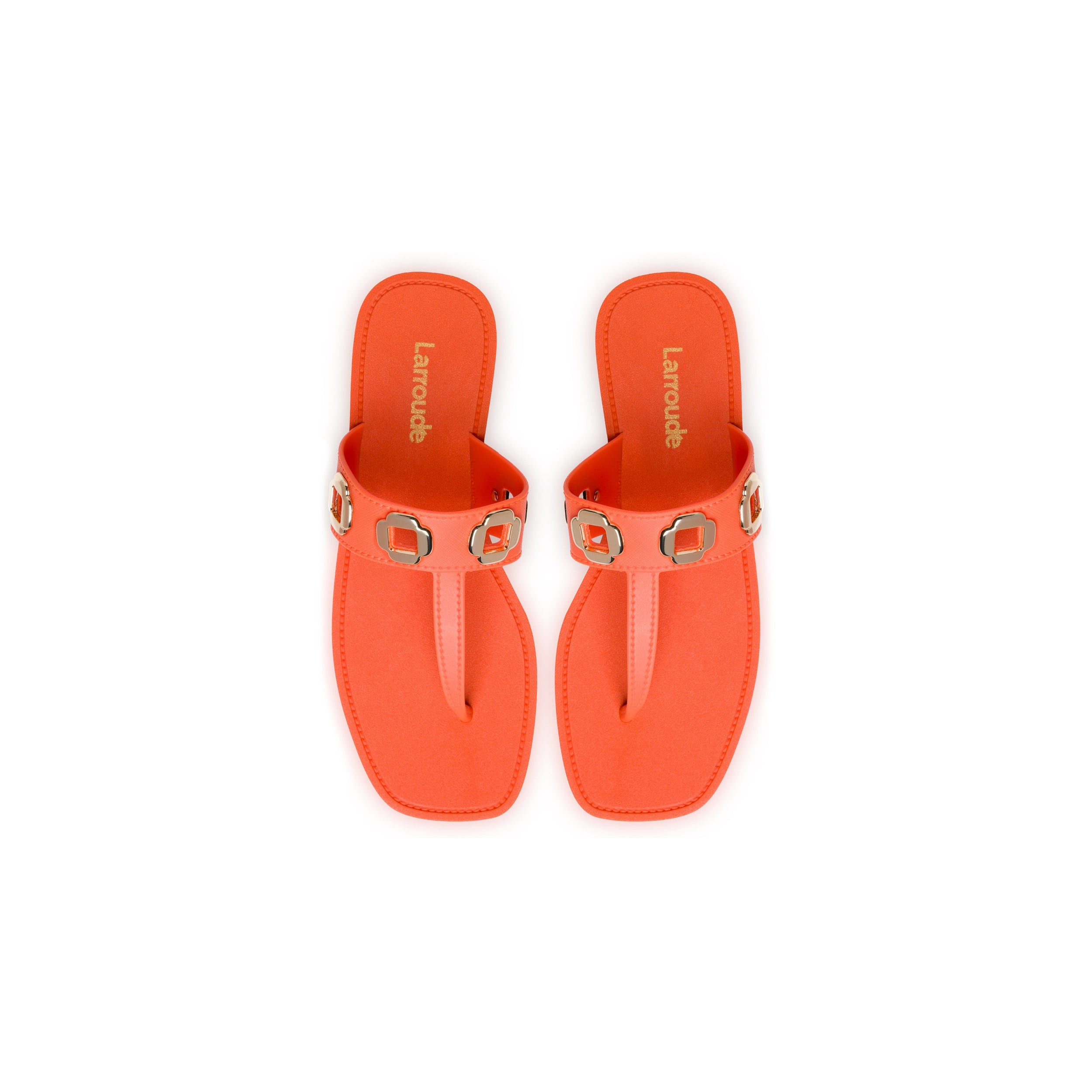 A pair of Milan S In Orange PVC with light brown insoles and the brand name "Lanoude" printed on them. Each sandal has a decorative strap featuring gold square buckles with circular centers. The sandals, rumored to be favored by the Milan family, are displayed against a white background.