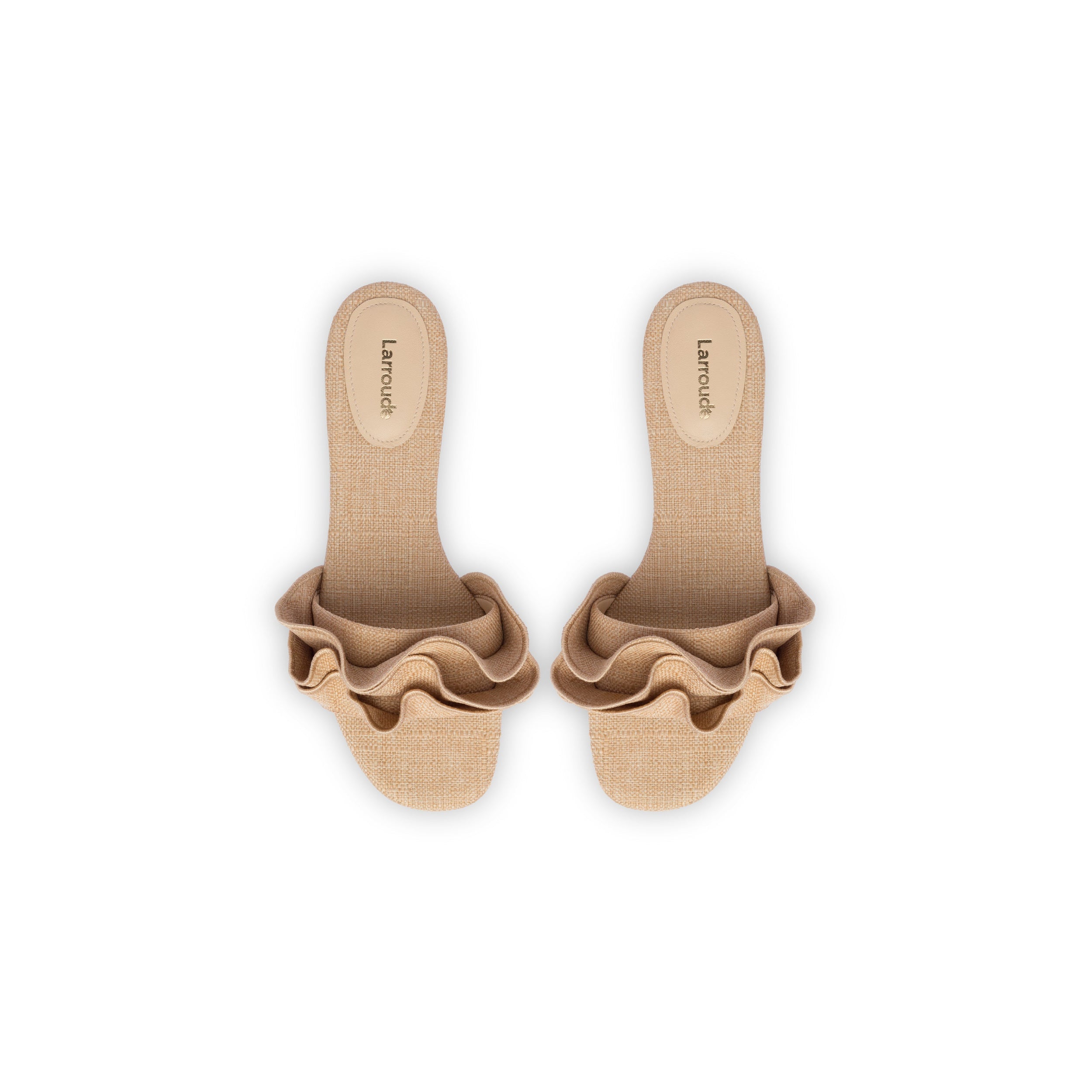 A pair of beige Ivy Ruffle Flat Mule sandals in raffia with cushioned insoles. This bestselling style features wide, textured straps adorned with ruffled detailing. The insoles bear the brand name "Larroudé" printed in black. They are laid out side by side on a plain white background.