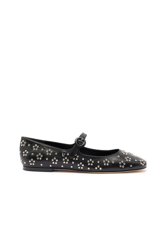 The Blair Ballet Flat in Black Leather and Metallic Studs is a single black leather Mary Jane flat shoe adorned with small silver studs in a floral pattern. It features a rounded toe, a strap with a buckle across the instep, and a memory foam cushion for added comfort. The flat sole is also black.