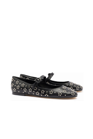 The Blair Ballet Flat in Black Leather and Metallic Studs is a pair of black leather Mary Jane flat shoes adorned with clusters of small silver studs arranged in a floral pattern. The shoes feature a rounded toe and a single strap with a circular buckle against a plain white background.