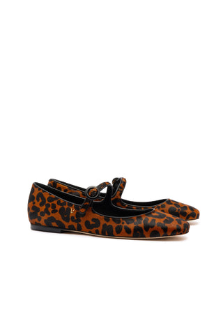 The Blair Ballet Flat in Leopard Print Calf Hair is a stylish pair of flat shoes featuring a rounded toe and a single strap with a buckle fastening over the top of the foot. They provide added comfort with memory foam cushions and showcase a leopard print design consisting of black spots on a brown and orange background.