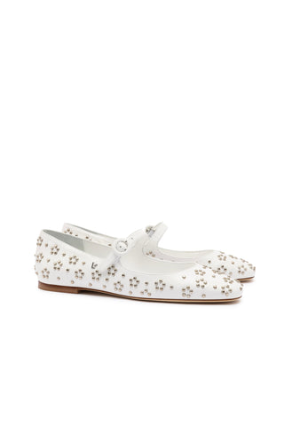 The Blair Ballet Flat in white leather features small metallic studs adorning its surface. These flats include a single strap with a round buckle and flat soles, blending classic elegance with a modern, edgy touch.