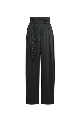 The Kora Double Belted Satin Pant in black by Noli Yoga is a high-waisted, wide-leg trouser with an attached black belt featuring multiple eyelets and a sleek silver buckle. These pants showcase elegant silver hardware and have pleated detailing on the front, offering a tailored yet relaxed look.