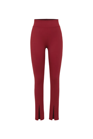 The Aura Legging - Merlot is a pair of high-waisted, deep red leggings with chic front slits at the ankles, perfect for your athleisure wardrobe, displayed on a plain white background.