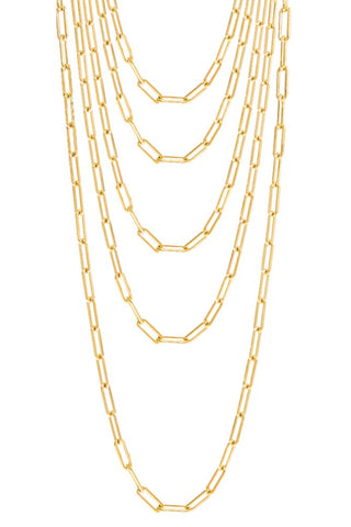 A display of seven layered, elongated rectangular link gold-plated necklaces by Adina Eden, varying in length and arranged in a cascading fashion. The polished chains are uniformly spaced, creating a visually appealing and symmetrical pattern. This versatile accessory adds elegance to any ensemble.