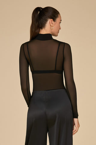 A person with long hair in a ponytail is wearing the Giselle Bodysuit in black mesh paired with satin pants, facing away from the camera against a plain beige background.